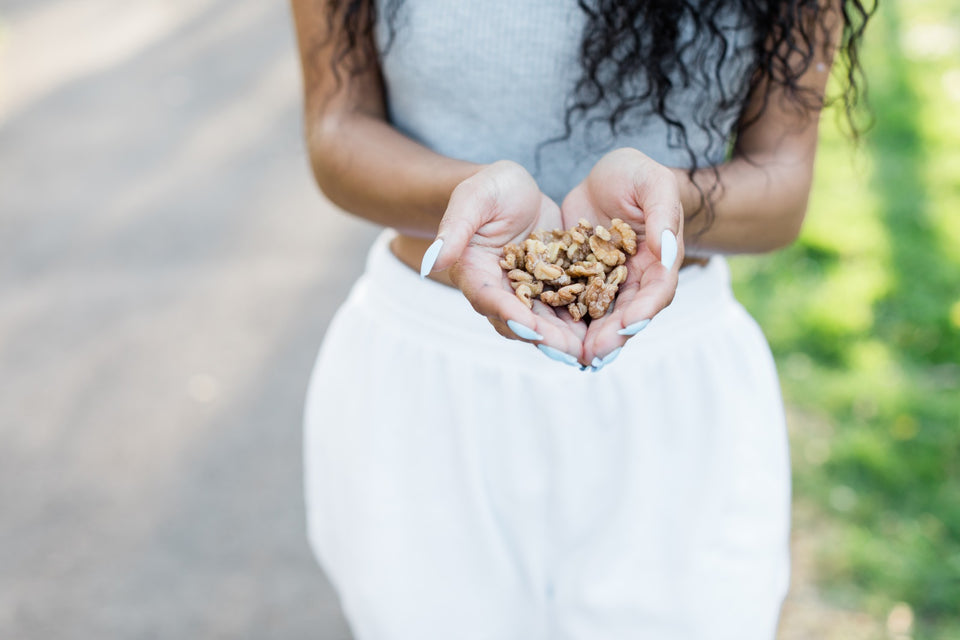 a woman holding sprouted walnuts on her hands